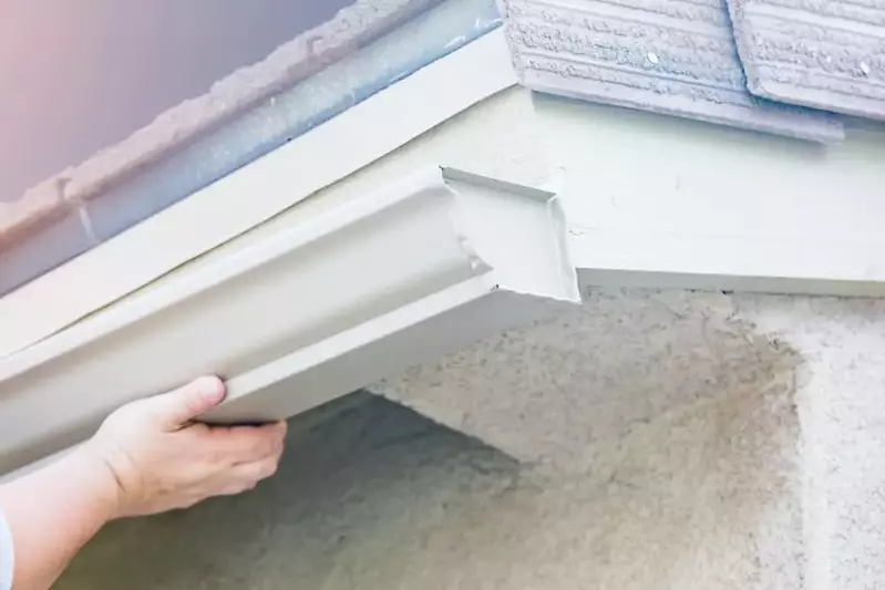 worker installing new aluminum gutters