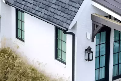 new black gutter system on white brick house