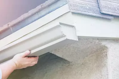 worker installing new aluminum gutters